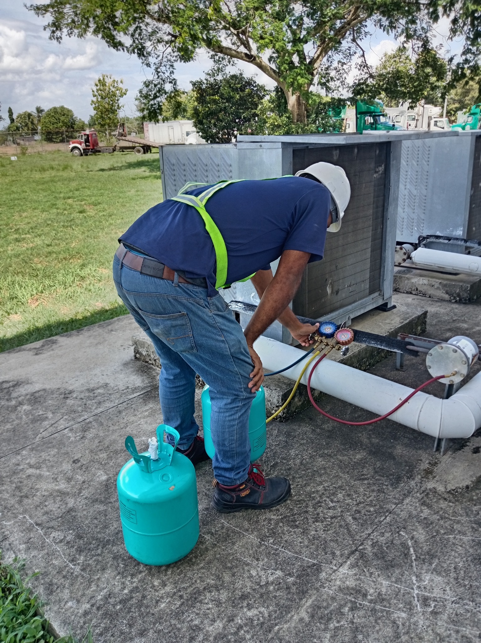 Técnico recargando gas refrigerante en condensadora